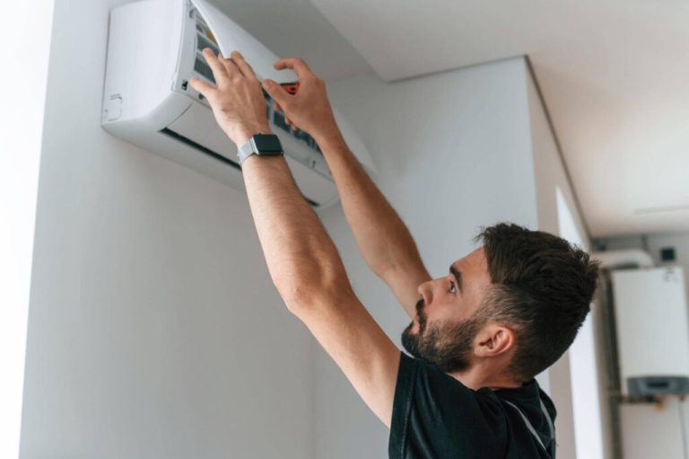 Technician servicing indoor air conditioner unit at home